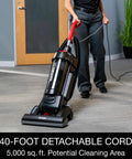 Heavy Duty Commercial Upright Vacuum Cleaner Featuring A Massive 15 Inch Wide Cleaning Path That Legit Crushes Carpet Dirt And Ground In Grime CRI Certified Beast Mode For Pro Cleaners. User operating vacuum with a long cord.
