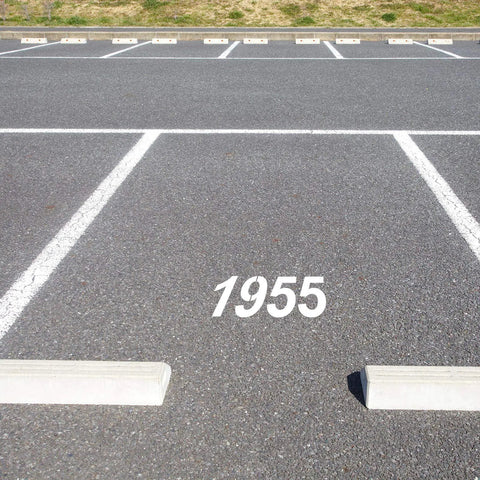 Parking lot with 1955 painted using Easy DIY Curb Address Stencil Kit with 0-9 Reusable Plastic Number Stencils, Includes 2 Rolls Masking Tape, 4 Inch High.