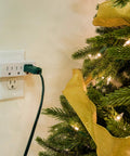 3-Outlet Wall Tap Extender 2 Pack Grounded Power Splitter For Home Office Dorm Use plugged next to a decorated Christmas tree