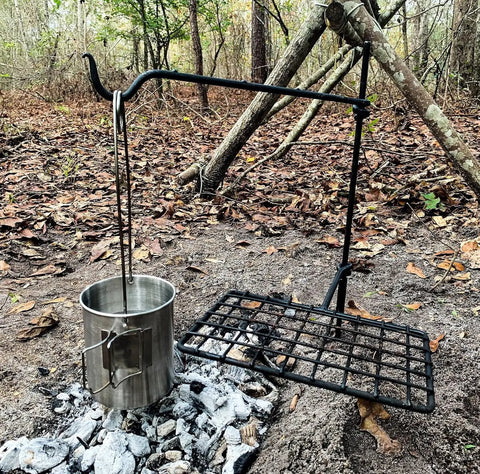 Swivel Grill Set For Campfire Cooking In The Great Outdoors with kettle hanging over embers, steel grate ready for use