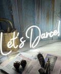 Dimmer Neon Sign For Wall Decor 21.3 By 17.3 Inch LED 3D Light In Cold White Perfect For Bedroom Bar Wedding Or Party Vibe Great Gift For Lovers And Friends Brighten Up Your Space With A Dope Neon Look displaying 'Let's Dance!'
