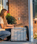 Woman opening package from the Versatile Outdoor Storage Cube Deck Box, a 25-gallon patio organizer.