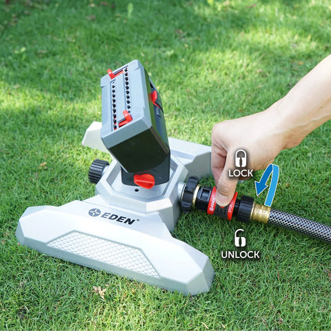 Person adjusting Metal Adjustable 4-Way Mini Turbo Oscillating Sprinkler With Quick Connect Starter Set on green lawn.