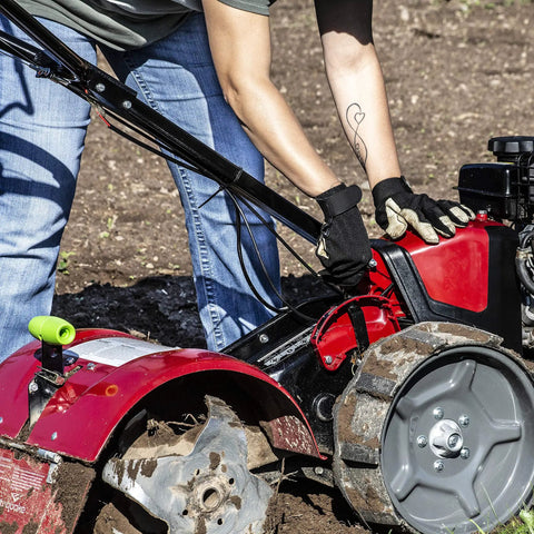 Person using Pioneer Dual Direction Rear Tine Tiller With Counter Rotating And Standard Rotating Tines on soil, red black machine