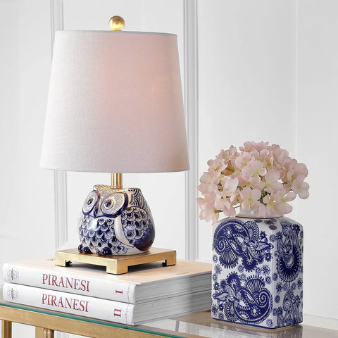 Blue White Ceramic Owl Table Lamp With Linen Shade on nightstand with books and vase