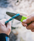 Person using Blunt Tip Paddle Knife With Serrated Blade And Quick Release Sheath Titanium Coated Three Inch Blade For Cutting Rope