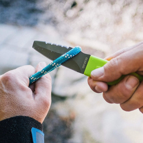 Person using Blunt Tip Paddle Knife With Serrated Blade And Quick Release Sheath Titanium Coated Three Inch Blade For Cutting Rope