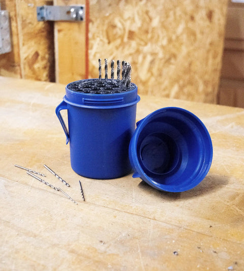 Blue Jobber Length Drill Bit Pod Organizer with 29 slots for 1/16 to 1/2 inch bits, twist lock lid open, shown with drill bits on workbench