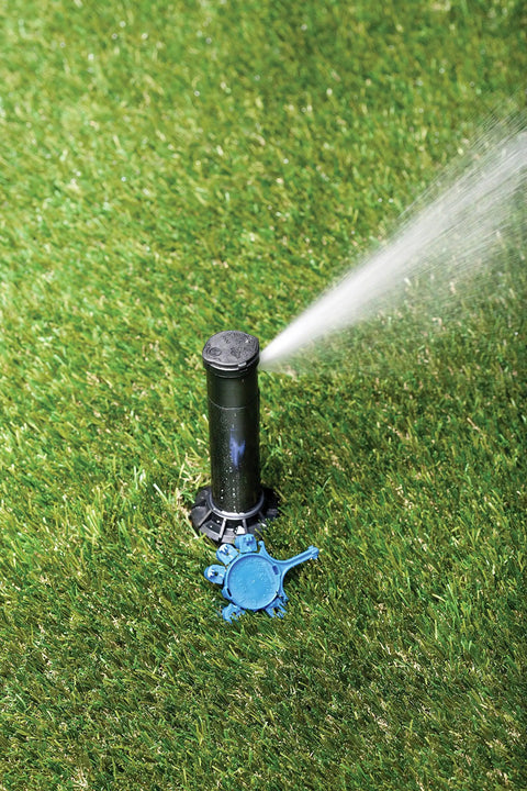 Pro Grade Gear-Drive Rotor With Rain Curtain Nozzles Set installed on lawn, spraying water over grass, 40 To 360 Degree Pattern.