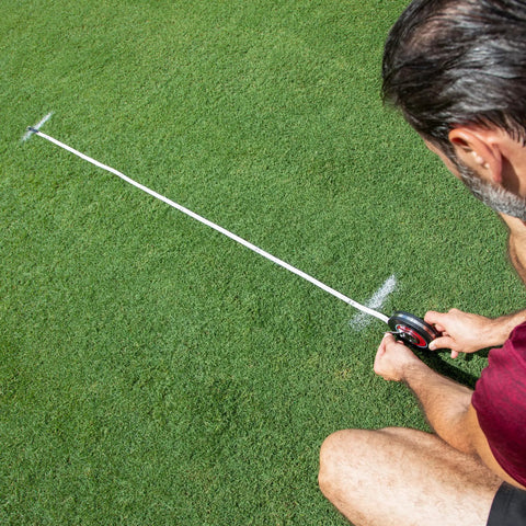 Man using Closed Reel Tape Measure 100 Ft 30 M Hand Crank Dual Sided Feet And Meters Long Measuring Tape For Indoor And Outdoor Projects