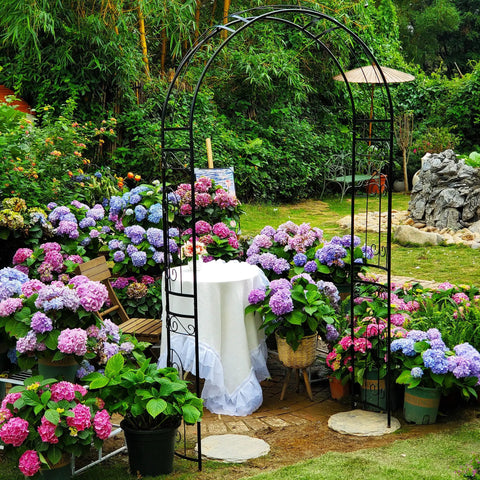 Heavy Duty Rustproof Iron Garden Arbor Wedding Arch, 95.3 Inch High By 45 Inch Wide in flower-filled outdoor setting