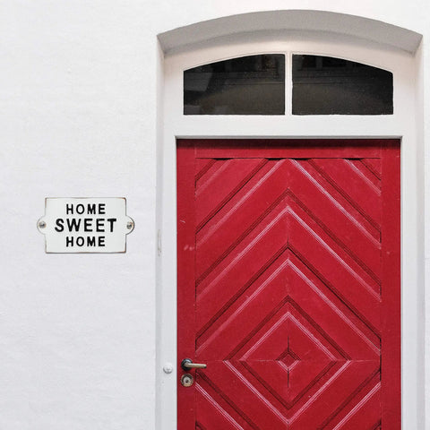 Built Like A Tank Cast Iron Home Sweet Home Wall Decor Featuring Distressed Antique White Finish on red door.