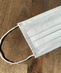 Made In USA 3 Layer Disposable Face Masks Bulk Pack 500 Count with ear loop on wooden surface