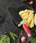 Crinkle cutter knife with red rubber handle and ribbed blade for fries and vegetables.