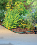 Installed view of Three Pack Multi Adjustable Spike Sprinklers With Quick Connect Bundle, Flow Through Base, in a garden bed.