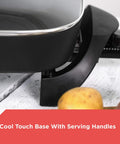 Close-up of electric skillet cool-touch handle with tempered glass lid. Electric Skillet With Variable Temperature Control And Nonstick Cooking Surface For No Mess Easy Cleanup Dishwasher Safe Tempered Glass Lid 12 By 15 Inch Pan For Searing Sauteing Simmering And Quick Weeknight Meals.