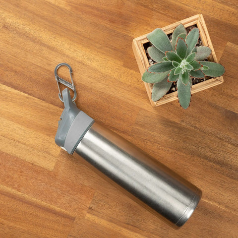 Size 3 SBiner Dual Carabiner Stainless Steel, Double Gated Clip attached to a water bottle on wooden table with plant