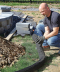 Worker installing Sediment Filter Sock For Erosion Control And Storm Drain Protection, 5 inch diameter, 10 foot long, black