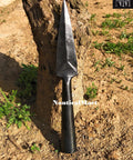 Hand Forged Viking Saga Iron Spear Point For Reenactment And LARP Carbon Steel Long Spearhead against a tree trunk.