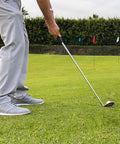 Golfer chipping on lawn with Three Pack Golf Flags For Backyard Practice And On The Go Chipping Drills in background