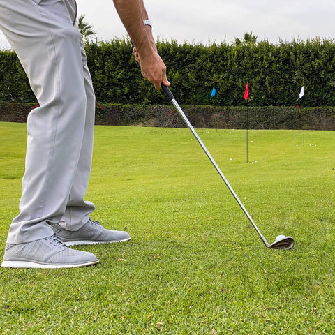 Golfer chipping on lawn with Three Pack Golf Flags For Backyard Practice And On The Go Chipping Drills in background