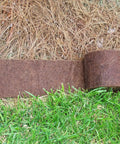 Border Protection Edging Weed Mat 10 Ft Long By 9 In Wide Brown Landscape Fabric laid between grass and pine straw
