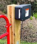 Workhorse 12 Volt 7 Ah Sealed Lead Acid Battery And Rugged Weatherproof Enclosure Kit With Complete Harnesses And Mounting Hardware For Gate Openers No Sweat Setup mounted on wooden post.