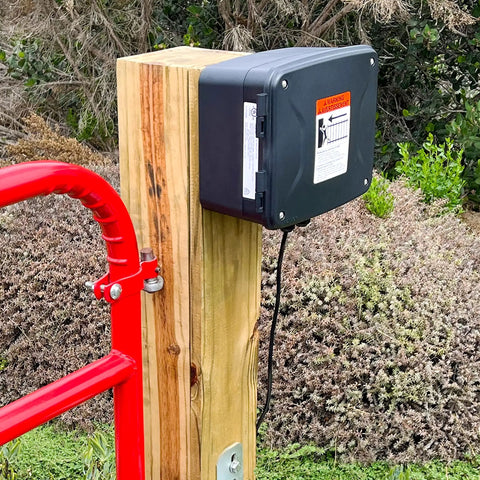 Workhorse 12 Volt 7 Ah Sealed Lead Acid Battery And Rugged Weatherproof Enclosure Kit With Complete Harnesses And Mounting Hardware For Gate Openers No Sweat Setup mounted on wooden post.