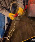 Worker using heavy duty ratchet load binder set four pack for flatbed trailer or truck with thirteen thousand pounds working load limit
