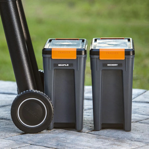 Level Up Your Smoke Game With This Heavy Duty Pellet Storage Bin Featuring A Rugged Locking Lid And Smart Stackable Design To Keep Wood Chips Bone Dry For Peak Grilling Days. Two stackable gray pellet containers labeled Maple and Hickory.