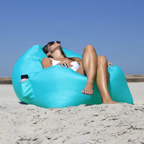 Woman relaxing on Inflatable Lounger Air Chair Lightweight Self Inflating Beach Chair with carry bag, teal color on beach
