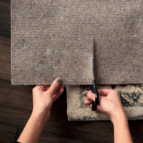 Person cutting Non Slip Rug Pad Basic Grey Cushioned Underlay Keeps Rugs From Slipping, Wrinkling, And Floor Scratches, Cut To Fit