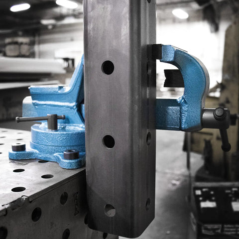 Heavy Duty 4 Inch Forged Steel Bench Vise With 4 Point Swivel Base 90000 PSI Tensile Strength Black Oxide Jaws on workbench