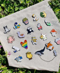 Dope And Super Cute Enamel Backpack Pins Bulk Set Loaded With Funny Anime Series Designs For Slaying Your Daily Outfit Premium Zinc Alloy Clasp For Backpacks Jackets And Helmets in colorful assortment on fabric.