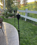 Conical Bronze Outdoor Torch Set For Backyards And Patios, Weather Resistant And Citronella Oil Compatible, installed in garden