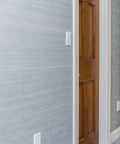 Tamper Resistant Duplex Receptacle White Wall Outlet 15 Amp Standard Decorative Electrical Outlet Contractor Pack With Wall Plates Included Easy Push In And Terminal Screw Installation 10 Pack seen on a grey wall next to a wooden door.
