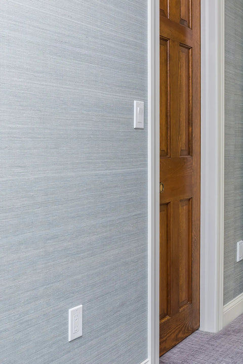 Tamper Resistant Duplex Receptacle White Wall Outlet 15 Amp Standard Decorative Electrical Outlet Contractor Pack With Wall Plates Included Easy Push In And Terminal Screw Installation 10 Pack seen on a grey wall next to a wooden door.