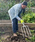 Person using Beefy Stainless Steel Digging Fork For Heavy Duty Garden Work, Durable Garden Tool For Digging, Aerating, And Turning Soil