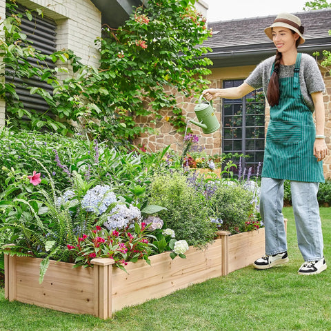 Person watering plants in Dual Section Divisible Wooden Raised Garden Bed 8 By 2 Feet Elevated Planter Box, backyard setting