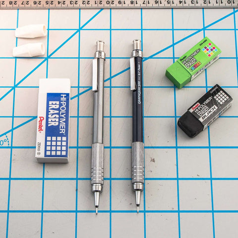 Graph Gear 500 Automatic Drafting Pencil 0.5mm with slick black barrel, shown with erasers and pencil caps on a grid surface.