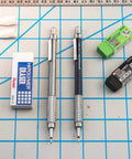 Graph Gear 500 Automatic Drafting Pencil 0.9mm with gray barrel and erasers on a grid background