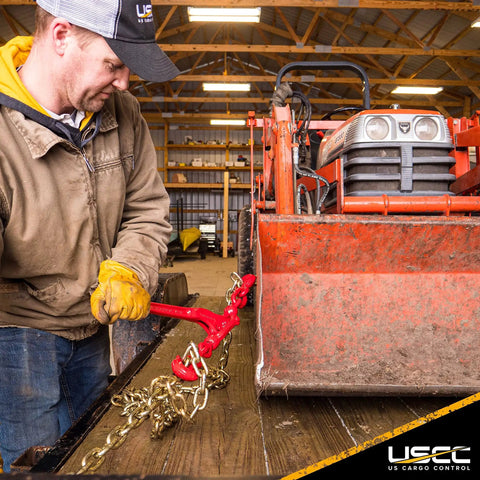 Man using Badass Heavy Duty Lever Load Binder For 516 Inch Grade 70 Chain With 5400 Lbs Working Load Limit to secure a load.