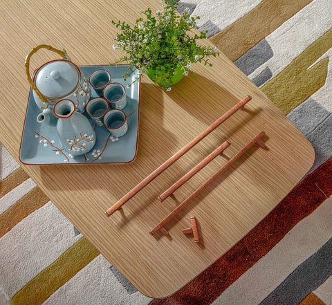 Overhead view of Six Pack 3 Inch Hole Center Antique Copper Zinc Alloy Cabinet Pulls displayed on a wooden surface with tea set.