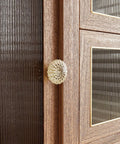 Close-up of a champagne gold crystal knob from the 8 Pack 1-3/8 Inch Champagne Gold Crystal Cabinet Knobs With Vintage Floral Design on a wooden cabinet.