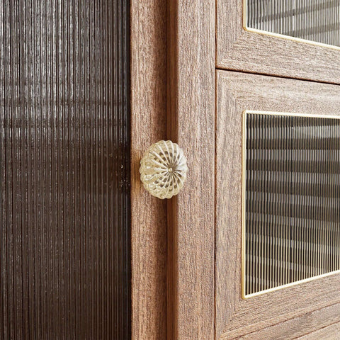 Close-up of a champagne gold crystal knob from the 8 Pack 1-3/8 Inch Champagne Gold Crystal Cabinet Knobs With Vintage Floral Design on a wooden cabinet.