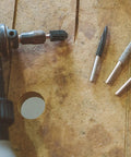 Sphere Rotary Burr One Eighth Inch Shaft Fine Grit Wood Carving Bit lying on wooden surface with rotary tool nearby