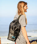 Man carrying Grande Portable Beach Tent Sun Shelter bag, showcasing compact storage, ideal for beach outings.