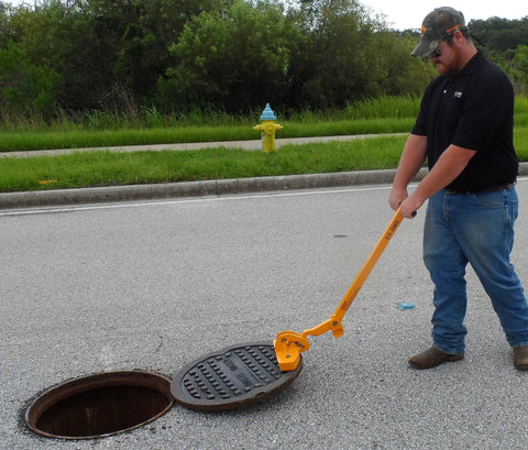 Kickass Three Magnet Manhole Lid Lifter Pulls Up To Two Hundred Fifty Pounds No Sweat featuring ergonomic handles lifting a manhole cover.