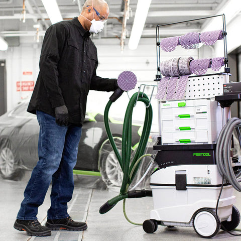 Technician using Cubitron II Net Disc Roll 6 Inch, 320 Grit, for precision sanding with dust extractor in auto workshop