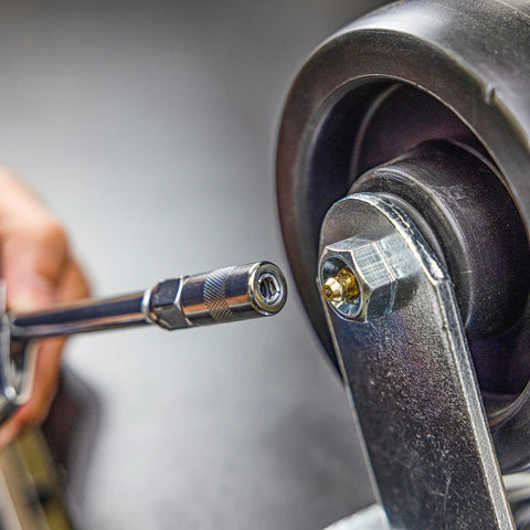 Close-up of Heavy Duty Mini Grease Gun Kit With Pistol Grip, 4500 PSI, 3oz Cartridges, Zerk Fitting on a wheel bearing.